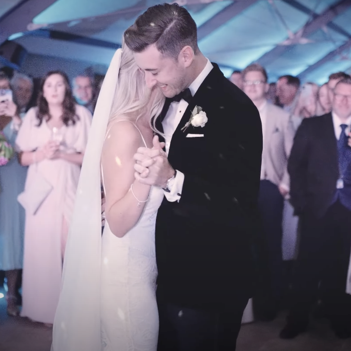 This photo shows a first dance of a bride and groom. It is captured from the perspective of a wedding videographer. 